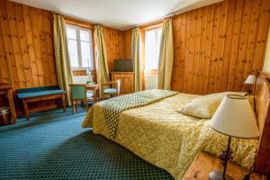 蒙乃第耶-勒潘Lautaret Lodge & Spa的酒店客房配有一张床铺和一张桌子。