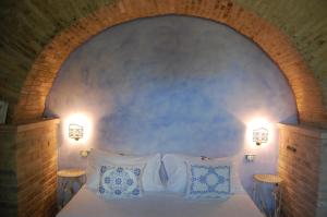 Monterubbiano文托罗斯住宿加早餐旅馆的卧室配有带两盏灯的白色床