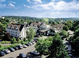 宁布雷希特Parkhotel Nümbrecht的享有一个小镇的空中景色,停车场停有车辆