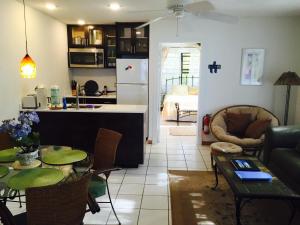 NCAHollywood Beach Suites Turks and Caicos的厨房以及带桌椅的起居室。