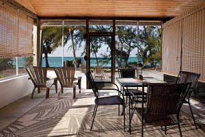 NCAHollywood Beach Suites Turks and Caicos的一个带桌椅的庭院和大海