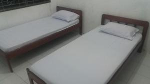 索龙彭金阿帕恩科菲亚度假屋的配有白色床单的客房内的两张床