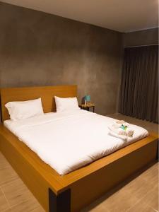 北冲白昼酒店的一间卧室配有一张带白色床单的大床
