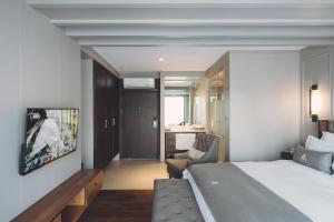 乔木提恩海滩Marine Beach Hotel Pattaya - SHA Plus的酒店客房带一张大床和一把椅子