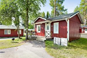 吕勒奥First Camp Arcus-Luleå的一条红色的小房子,有一条通往它的道路