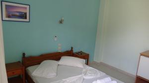 波罗斯Poros House Hotel的一间卧室配有带白色床单和枕头的床。