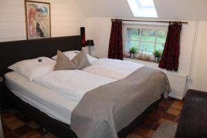 旺格兰兹姆滕克鲁格旅馆的卧室内的一张带白色床单和枕头的大床