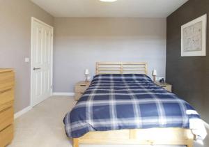 瓦灵福德D&E Homestay的一间卧室配有一张带蓝白色布艺毯的床