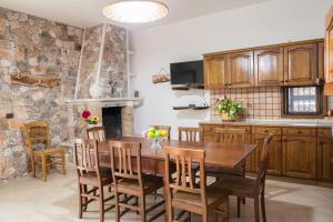 莱乌卡Villa Pietra Incantata的厨房以及带木桌和椅子的用餐室。