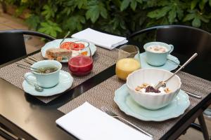 里斯本里斯本奶酪及葡萄酒套房酒店的一张桌子,上面放着一碗食物和两杯咖啡