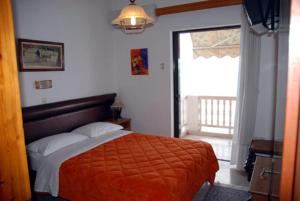 阿克拉塔安东尼奥斯旅馆的一间卧室配有一张带橙色毯子和窗户的床。