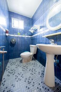 绿岛绿岛蓝海奇缘民宿的蓝色瓷砖浴室设有卫生间和水槽