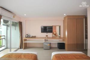 呵叻素克哈玛斯皮罗姆酒店的一间卧室配有两张床、一个水槽和一台电视。