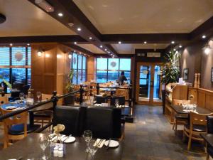 安斯特拉瑟水滨旅舍的餐厅内带桌椅的用餐室
