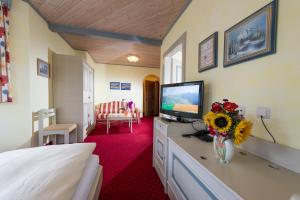 格罗萨尔索恩霍夫酒店的酒店客房,配有床铺和梳妆台上的电视