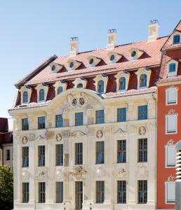 德累斯顿Hapimag Ferienwohnungen Dresden的一座白色的大建筑,有红色的屋顶