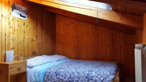 奥斯塔欧洲滑雪住宿加早餐旅馆的卧室配有木墙内的一张床