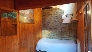 奥斯塔欧洲滑雪住宿加早餐旅馆的一间卧室设有一张床和石墙