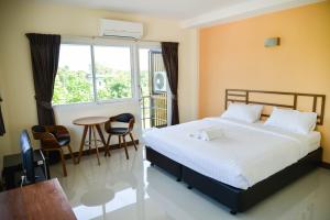 程逸府泰米特度假酒店的一间卧室配有一张床、一张桌子和一个窗户。