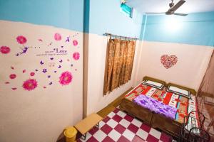 瓦拉纳西索密特佩英宾馆的一间卧室设有一张床和鲜花墙
