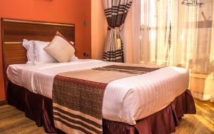 内罗毕40之后酒店的一间卧室配有一张带橙色墙壁的大床