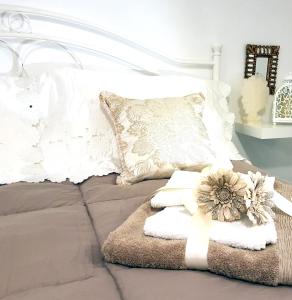 莫诺波利Civico 20 Casa d'arte的一张带白色枕头的床和毛巾