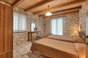 瓦西里科斯Villa Socrates的一间卧室设有两张床和石墙