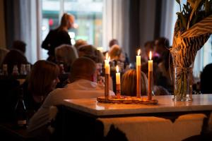 卡尔马Frimurarehotellet; Sure Hotel Collection by Best Western的一群人坐在桌子上,拿着蜡烛