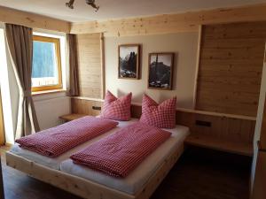 乌姆豪森Gasthof Leiter´s Hoamatl的一间卧室配有两张带红色枕头的床