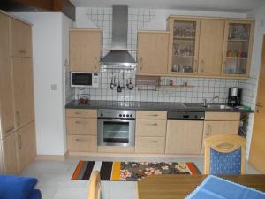 东蒂罗尔地区马特赖豪斯赫尔佐格公寓的厨房配有木制橱柜和炉灶烤箱。