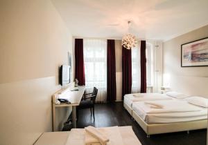 柏林柏林普恩斯酒店的酒店客房配有两张床和一张书桌