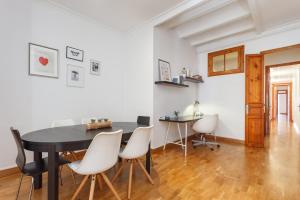 巴塞罗那Flateli Aribau的一间用餐室,配有黑桌和白色椅子