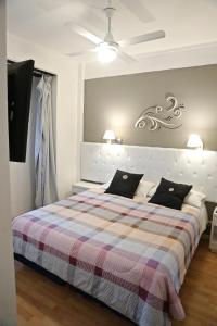 马德普拉塔Dodo Suites的一间卧室配有一张大床和一张铺着条纹毯子