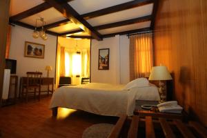 圣地亚哥维加斯酒店的一间卧室配有一张床和一张桌子及电话