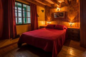 Tajace de AbajoCasa Elvira的一间卧室配有一张带红色毯子的床和窗户。