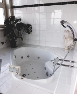 鹿特丹山姆斯普莱斯公寓的白色浴缸,配有水龙头和植物
