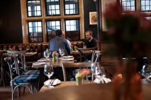泰晤士河畔金斯顿白鹿酒店的一群坐在餐厅桌子上的人