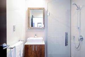 奥克兰No. 9 Hotel的浴室配有盥洗盆和带镜子的淋浴