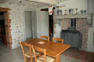 AmbronayLe Bellaton的一间带木桌和燃木炉的用餐室