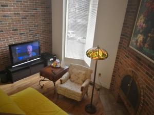 多伦多玛吉联排别墅套房的客厅配有沙发、电视和灯具