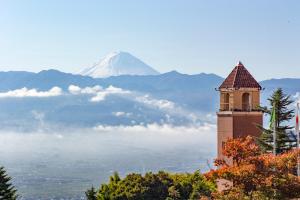 山梨市富士屋水果公园酒店的一座以山为背景的钟楼