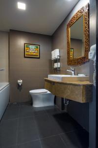 北芭堤雅爱雅拉宫殿酒店的一间带水槽、卫生间和镜子的浴室