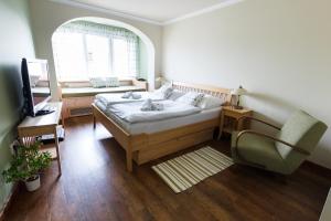 诺夫梅斯托纳马瑞夫潘斯基杜姆酒店的一间卧室配有一张床、一张桌子和一把椅子