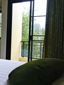 攀牙T.P.普莱斯酒店的一间卧室设有大窗户和一张带枕头的床