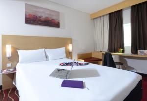 麦纳麦ibis Seef Manama的酒店客房,配有一张带笔记本电脑的床
