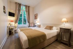 图尔瓦勒德洛尔酒店的一间卧室配有一张床、一张书桌和一个窗户。