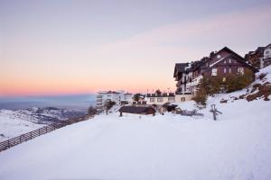 塞拉内华达鲁麦基伊亚精选文奇酒店的一座雪覆盖的山丘上建有建筑物