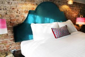 都柏林House Bedrooms Dublin的一间卧室配有一张带绿色床头板的床和两盏灯。