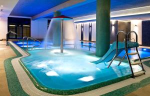埃尔布隆格Hotel Młyn Aqua Spa Biblioteka的一个带水滑梯的游泳池