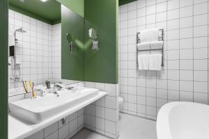 敖德萨City Hotel Bortoli by Ribas的白色的浴室设有水槽和绿色的墙壁